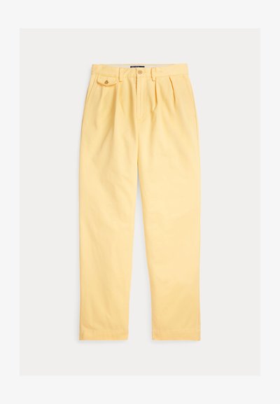 Ljusgula bomullsbyxor med avslappnad passform, utrustade med plisserad fram, hällor för bälte och en enda framficka med knappstängning.