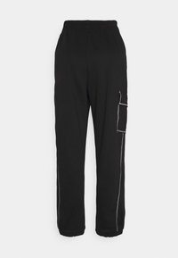 Pantalones de chándal negros con cinturilla ajustable, bolsillo lateral en la pierna derecha y puños elásticos. Tela suave con costuras en contraste.