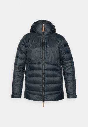 Casaco puffer azul escuro com capuz, apresentando um fecho totalmente zipado, punhos elásticos e um acabamento texturizado. Acento de pele na gola com cordões.