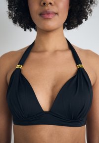 Svart bikini topp med dyp V-hals, rynket stoff og gullfargede detaljer på stroppene. Glatt tekstur perfekt for badetøy.