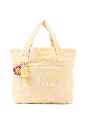 Sac cabas aux fleurs douces roses et jaunes, avec doubles poignées, poche avant, logo "Chloé" et deux petits porte-clés en fleurs crochetées attachés.