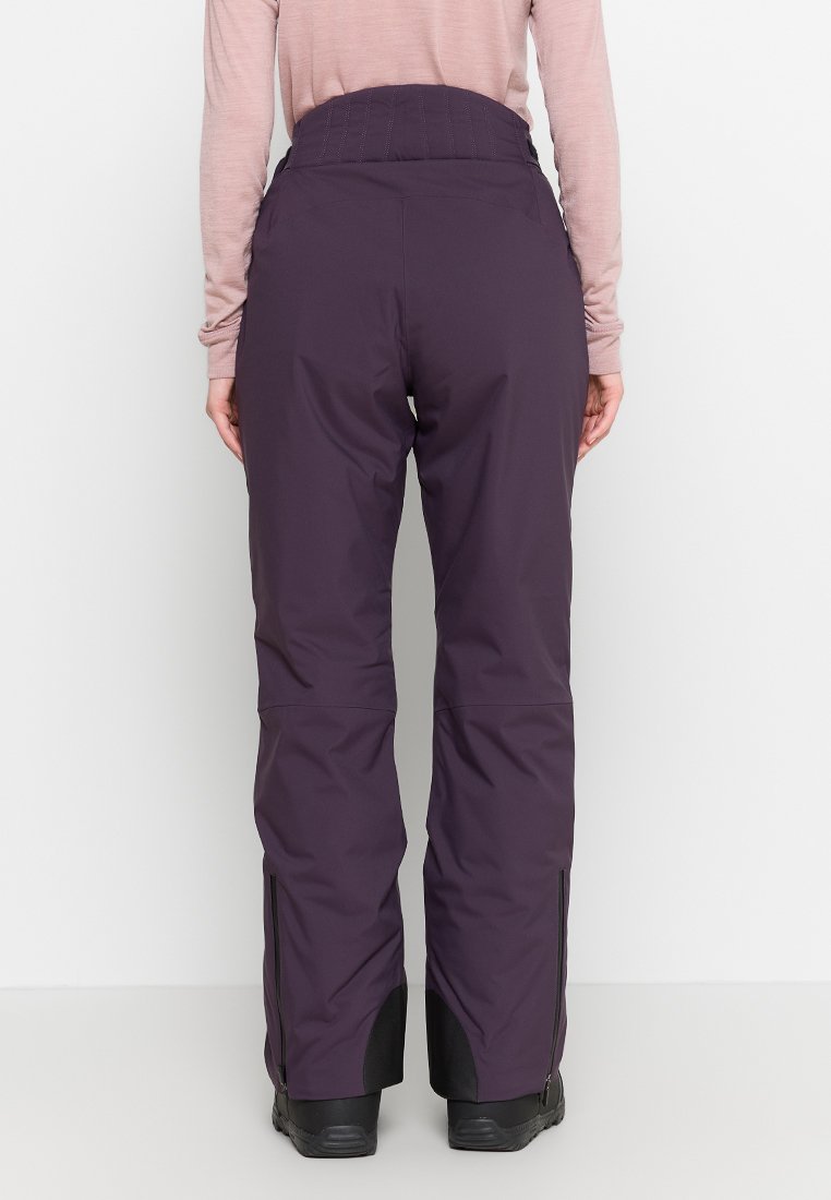 Lila Skihosen mit hohem Bund, seitlichen Reißverschlüssen an den Knöcheln und einem glatten, strapazierfähigen Stoff, der sich für Winteraktivitäten eignet.