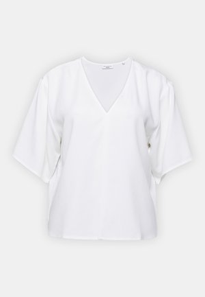 Hvid kortærmet bluse med V-hals, lavet af glat stof. Har en løs pasform og slidser i siderne for øget komfort og stil.