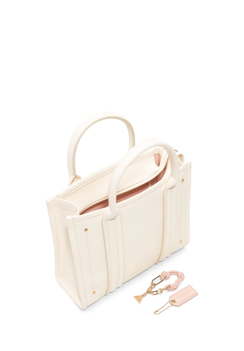 Sac à main en cuir blanc à la conception structurée, fermeture zippée et deux poignées courtes. Comprend un porte-clés rose et une petite étiquette en cuir.