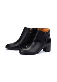 Bottines en cuir noir avec une finition lisse, bout pointu, fermeture éclair sur le côté et panneau arrière texturé. Design à talon bloc.