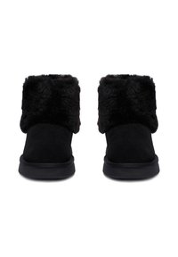 O pereche de ghete negre până la glezne, cu manșete groase, moi și pufoase, și talpă din cauciuc plat, prezentate din față pe un fundal alb.