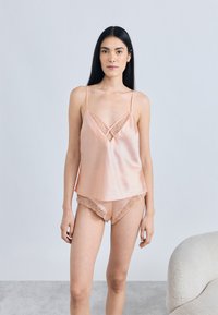 Virsipea satiinist kamisool pitsdetailide ja sobivate lühikestega, millel on geomeetrilised pitsaktsendid, kerge ja sile tekstuur.