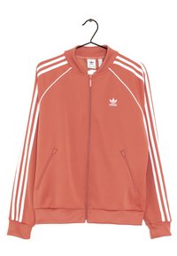 Adidas sportovní bunda v korálové barvě s bílými pruhy, plný zip vpředu, stojáček a dvě boční kapsy. Vyrobena z hladkého materiálu.