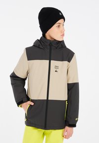 Isolierte Jacke in Beige, Dunkelgrau und Schwarz, mit Kapuze, Reißverschlusstaschen, Logodetail und leuchtend gelben Akzenten. Weicher, strukturierter Stoff.