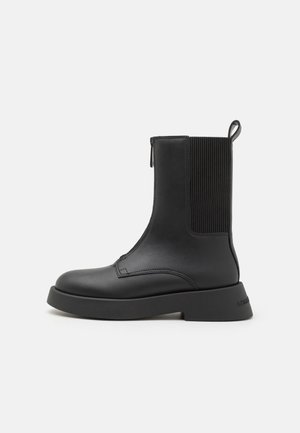 Stivali ankle neri con tomaia in pelle liscia, pannelli laterali elastici e suola in gomma spessa. Presentano un pratico linguetta sul retro per una facile calzata.