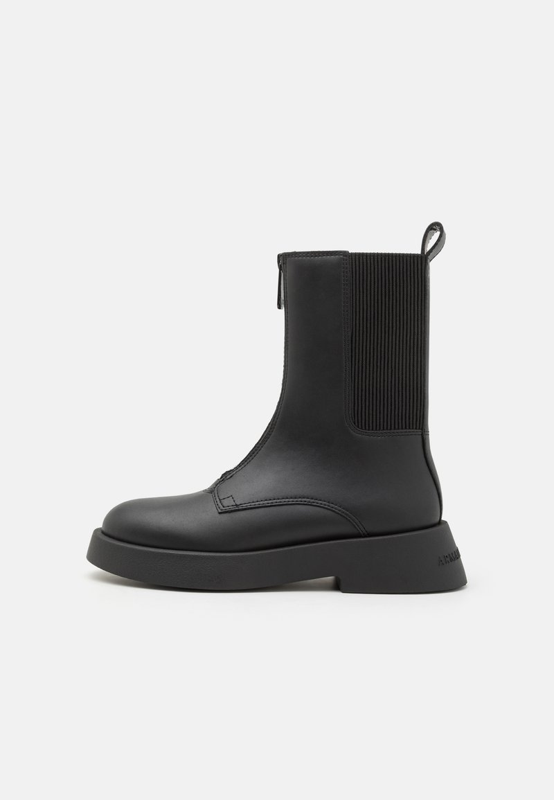 Stivali ankle neri con tomaia in pelle liscia, pannelli laterali elastici e suola in gomma spessa. Presentano un pratico linguetta sul retro per una facile calzata.