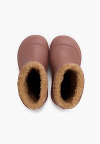 Roze rubberen laarzen met een zachte tan nepbont voering, ronde neuzen en een gestructureerde zool, ontworpen voor comfort en warmte.