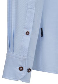 Helles blaues Button-Down-Hemd mit einem karrierten Muster, featuring braunen Knöpfen, einem geknöpften Ärmel und dezenten Fältchen für zusätzliche Textur.