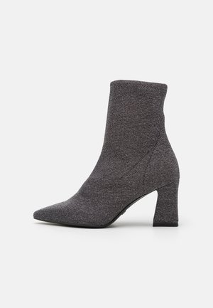 Grey knit ankle boot with a pointed toe and mid-height block heel. Smooth texture with minimal stitching details.