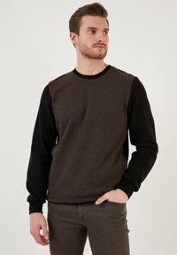 Black and brown sweatshirt featuring a textured body with a herringbone pattern, solid black sleeves, and a round neck design.