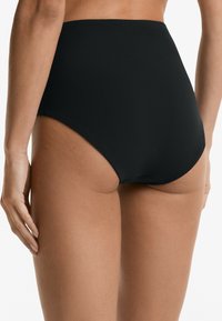 Magas derekú fekete bikini alsó, sima textúrával és letisztult vonalakkal, mérsékelt kivágással és varrás nélküli dizájnnal.