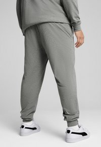 Grå sweatpants i en afslappet pasform med ribbede manchetter, tekstureret stof og sidelommer. Sammen med hvide sneakers med sorte accenter.