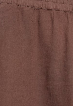 Smeđa tkanina s naboranim elastičnim pojasom, koja prikazuje teksturu i fine detalje šavova na šavovima pojasa.