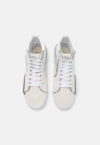 Høje sneakers i hvid læder med suedeelementer, der har sorte sidestipes og klassiske hvide snørebånd. Perforeret tådesign.