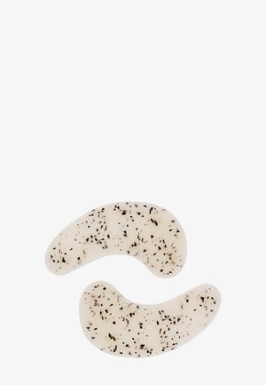Twee maansikkelvormige doorschijnende gel oogpatches met zwarte vlekjes op een witte achtergrond.
