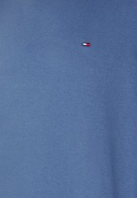 T-shirt in cotone blu con un piccolo logo con accenti rossi, bianchi e blu. Texture morbida con un design classico a girocollo.