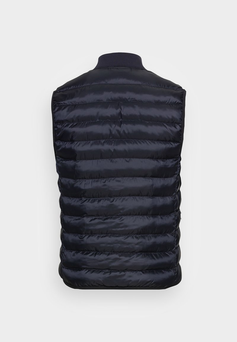 Gilet matelassé bleu marine avec un col côtelé, présentant des panneaux matelassés horizontaux et une texture lisse et brillante sur le tissu.