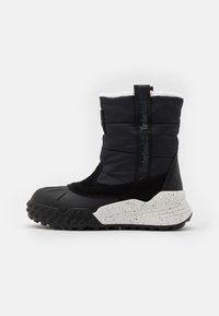 Czarny wodoodporny but z wyściełanym wierzchem o pikowanym wzorze, białą, nakrapianą środkową podeszwą i solidną gumową podeszwą zapewniającą przyczepność.