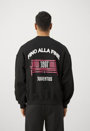 Schwarzer Kapuzenpullover mit dem Text "FINO ALLA FINE" in weiß und pink, mit "1897" und "JUVENTUS" in fetter Schrift auf dem Rücken.