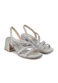 Sandalias de tacón plateadas con un diseño de tiras adornado con strass claros, una textura metálica suave y un tacón cuadrado.