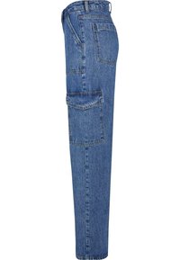 Pantalon cargo en denim bleu avec poche à rabat latérale, poche arrière, passants de ceinture et coupe droite, vu de côté.