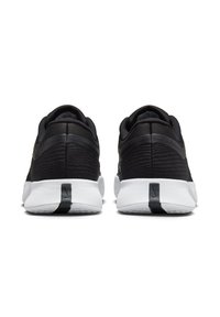 Schwarze Sportchuhe mit einem strukturierten Mesh-Obermaterial, weißen Sohlen und kontrastierenden schwarzen Akzenten an der Ferse und Rückseite. Minimalistisches Design.
