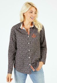 Chemise à manches longues en tissu sombre avec un motif floral ; dotée d'un col contrasté et d'un design brodé sur la poitrine.
