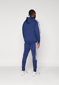 adidas Sportswear HOUSE OF TIRO NATIONS PACK - Träningsbyxor - team navy blue/white/better scarlet