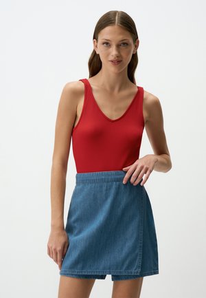 Rode geribde tanktop met een diepe V-hals, gecombineerd met een blauwe denim wikkelfrok. De rok heeft een aansluitende taille en casual drapering.