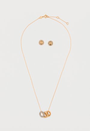 Conjunto de joias em tom de ouro, composto por um colar com anéis interligados (um com pedras transparentes) e brincos redondos de cada lado com acentos padrões.