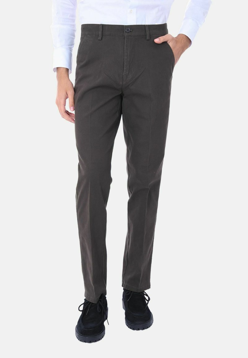 Pantaloni in cotone grigio scuro da uomo, vestibilità slim, frontale piatto, tasche laterali, chiusura con bottone e fondo con risvolto, abbinati a scarpe nere.
