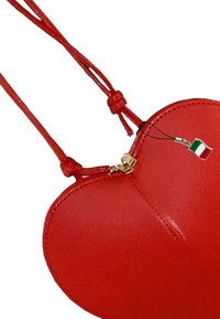 Rode leren tas in de vorm van een hart met een gestructureerd oppervlak, gouden rits en rode kanten handvatten. Inclusief een bedeltje van de Italiaanse vlag.