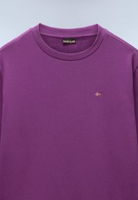 Lila Sweatshirt mit Rundhalsausschnitt und gerippten Bündchen, mit einem kleinen aufgestickten Flaggenmotiv auf der Brust. Weiches Baumwollmaterial.
