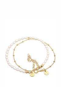 Zelta rokassprādze ar baltām neregulārām pērlēm un zelta akcentiem. Komplektā ķēdes pagarinājums ar omāra aizdari un divām mazām etiķetēm ar atzīmi "925".