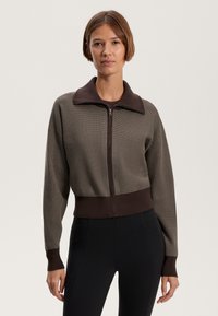Brown and gray cropped zip-up sweater with ribbed texture, collar, and cuffed sleeves. Paired with black leggings.