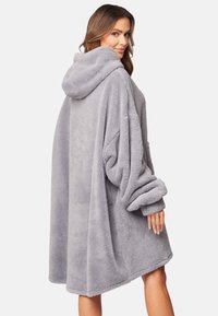Sudadera gris acogedora de gran tamaño hecha de un material suave y de felpa, con un gran bolsillo y puños doblados, que cuenta con capucha y una silueta holgada.