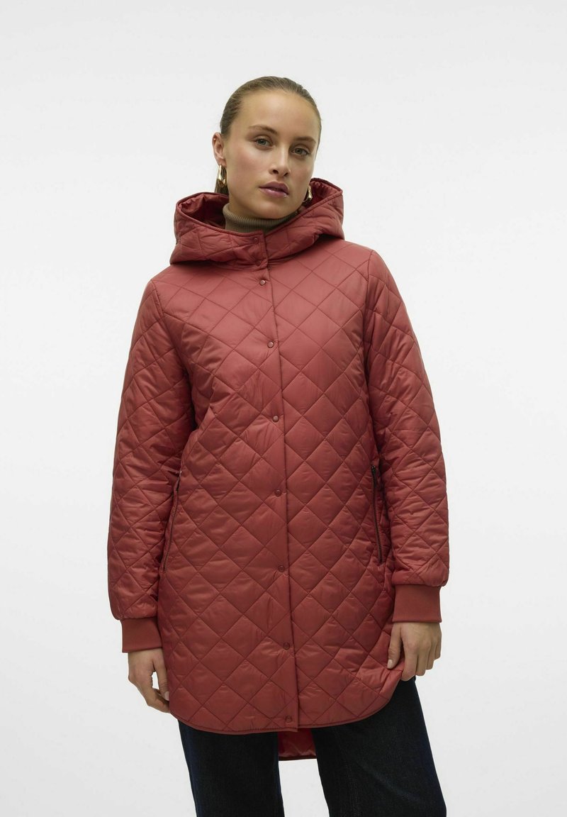 Manteau matelassé de longueur genou en couleur rose, avec une capuche, une fermeture à pression, des poches latérales et des poignets côtelés. Fini lisse et brillant.