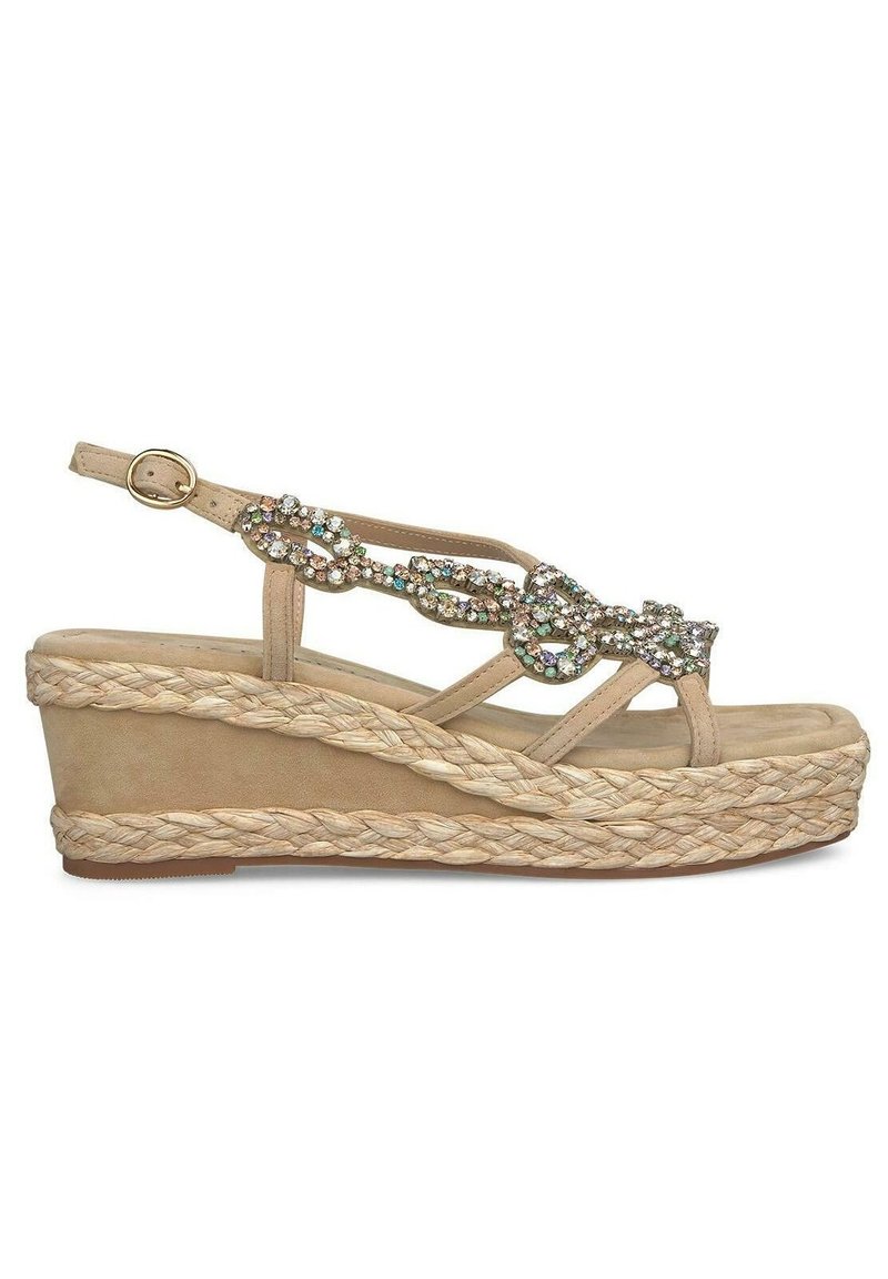 Sandale à talon compensé beige avec une plateforme en jute tressé, ornée de gemmes multicolores scintillantes sur la bride. Fermeture à boucle réglable au niveau de la cheville.