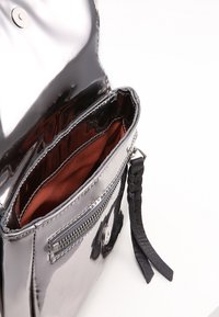 Borsa in pelle verniciata nera con chiusura a scatto magnetico, dotata di tasca con zip e manico intrecciato; interno foderato in tessuto borgogna.