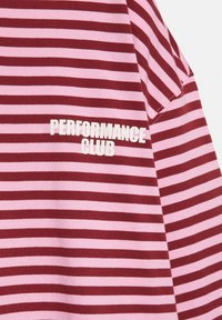 Pink and dark red horizontal striped fabric with "PERFORMANCE CLUB" printed in white bold letters.