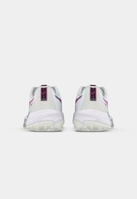 Białe sneakersy z jasnoszarymi akcentami, fioletowymi detalami i teksturowanymi podeszwami. Widok z tyłu ukazuje logo na pięcie oraz gładki design materiału.