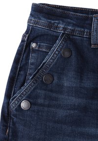 Vaqueros de mezclilla azul oscuro con un diseño de cinco bolsillos, botones de metal y costuras en contraste. Textura suave con un desvanecimiento mínimo.