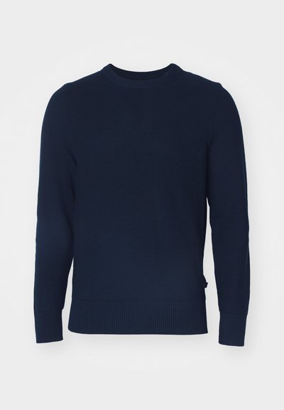 Tumedast sinine kudum-sviiter ümmarguse kaelusega, pikkade varrukatega, ribakraanide ja äärtega, millel on kogu pinnal tekstureeritud muster.