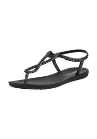 Black sandals with a textured footbed, featuring braided straps and a thin ankle strap with decorative studs. Flat sole design.