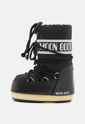 Zwarte waterdichte laars met een gepolsterde nylon bovenkant, vetersluiting, witte branding op de boord en een dikke beige zool. Textuurafwerking.